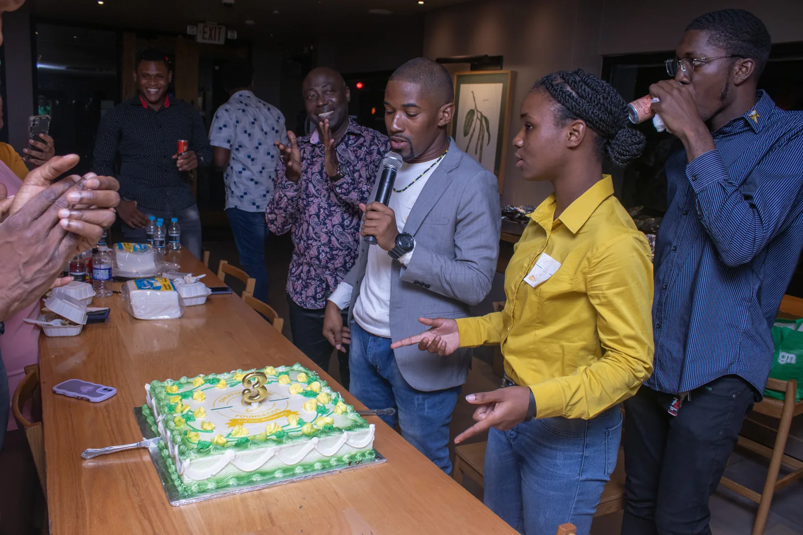 People gathered around an anniversary cake