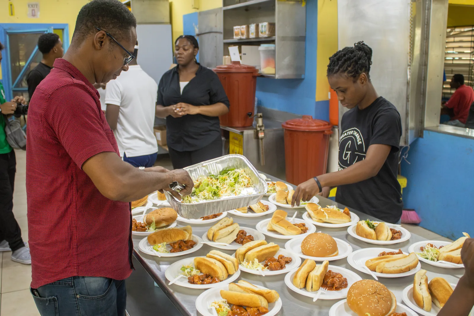 Volunteers arranging prepared meals in the kitchen