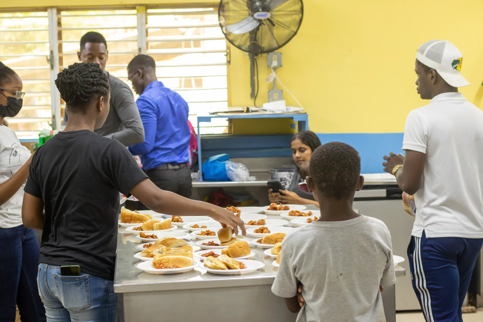 GCF participants serving plates of food from a kitchen counter